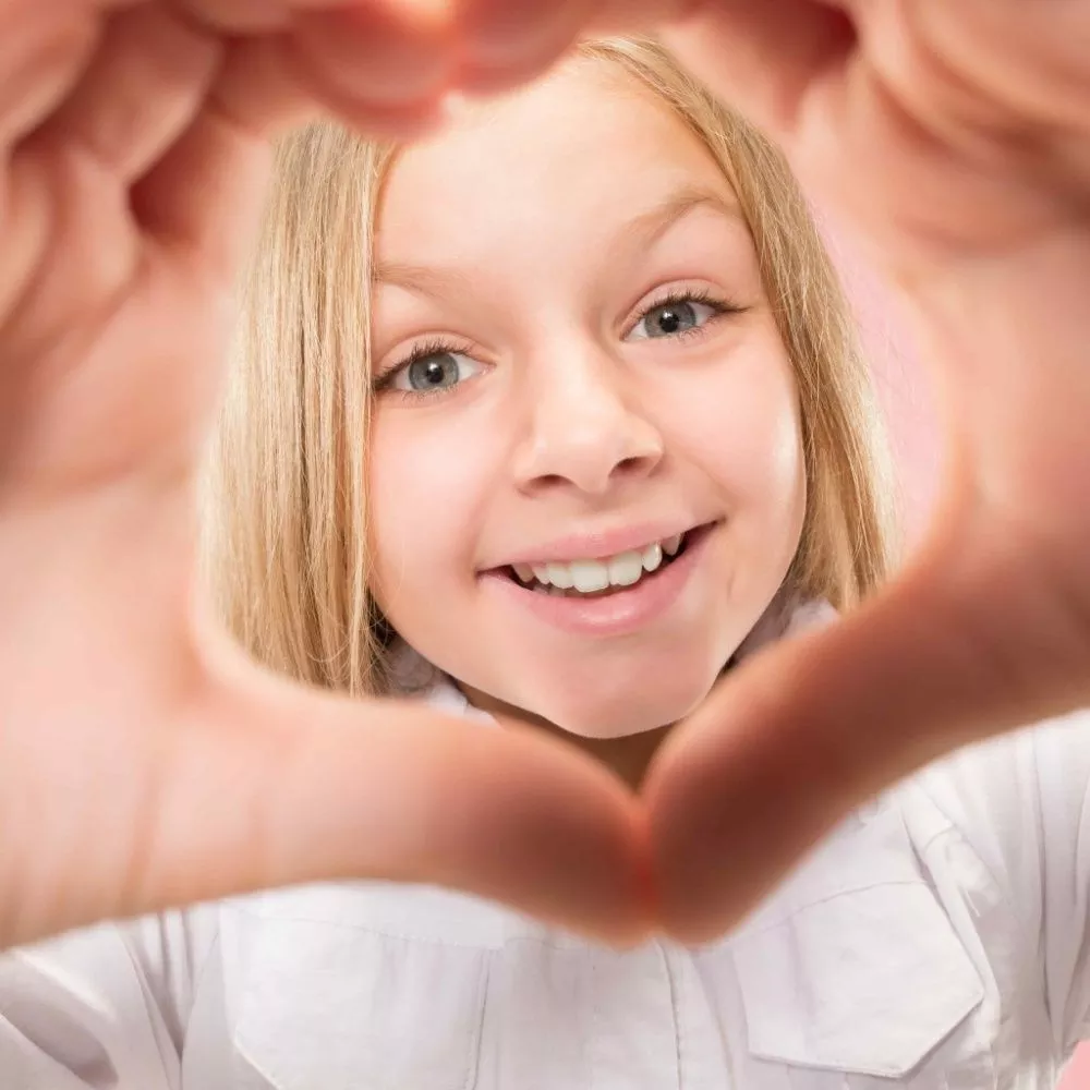 beautiful-smiling-teen-girl-makes-shape-heart-with-her-hands-pink-background-gesture-love-by-pretty-young-child (1).jpg